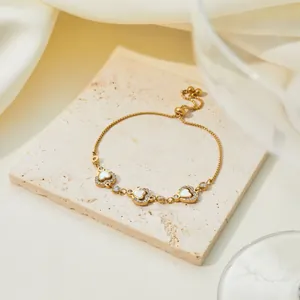 Macro view of gold-plated stainless steel bracelet with heart-shaped shell inlays