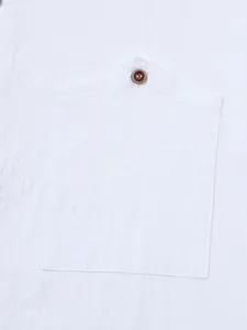 Detailed macro view of a white linen shirt pocket with a classic wooden button.