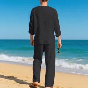 Lockeres schwarzes Leinen-Set für Herren mit Langarmshirt und Hose am Strand für Urlaub.