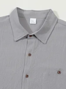 Close-up of a grey linen shirt collar with visible fabric texture and size label.