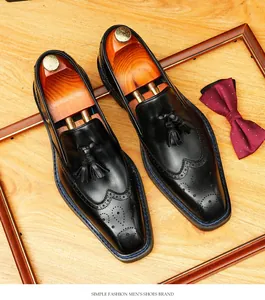 Top view of men's black leather tassel loafers with brogue wingtip detailing