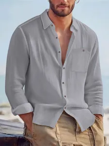 Model wearing a casual grey long-sleeve linen shirt for men in a beach setting