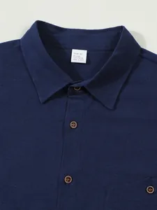 Close-up detail of a dark blue men's linen shirt collar with a size M label and button