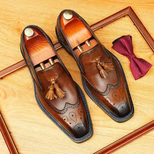 Classic brown leather tassel loafers with wingtip brogue detailing and square toe
