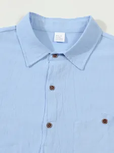 Close-up of men's light blue linen shirt collar showing fabric texture and size label.