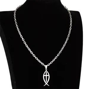 Macro view of a polished stainless steel Ichthys fish and cross pendant necklace.
