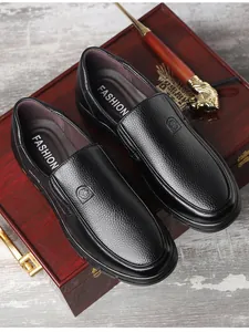Nahaufnahme klassischer schwarzer Herren-Leder-Loafer auf einer Vintage-Holzbox
