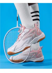 Chaussures de badminton roses pour enfants avec boucle rotative et raquette blanche.