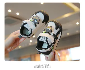 Soft sole toddler shoes with cute cartoon patches in black and white sporty design.