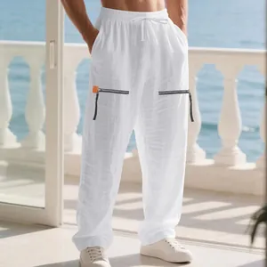 Vue détaillée d'un pantalon de plage blanc en lin ample avec zips décoratifs latéraux