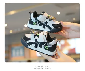 Detail view of black and white toddler sneakers featuring a cute cartoon owl decoration