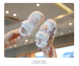 Detailed view of pink baby girl walking shoes with soft soles and cartoon patches.