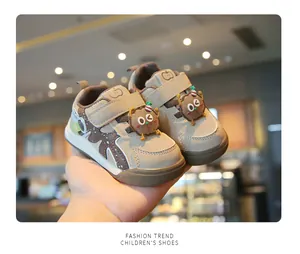 Close-up of cute infant soft-sole walking shoes featuring decorative cartoon cookie detail