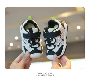 Gros plan de baskets pour tout-petits en noir et blanc avec velcro et semelles souples.