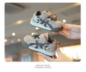 Close-up of beige infant walking shoes with cute cookie character and velcro strap