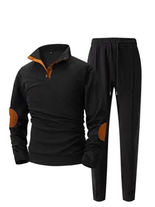 Detail view of men's two-piece black waffle knit tracksuit with orange elbow patches