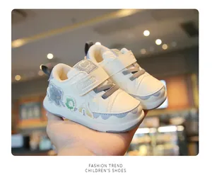 Detail view of white toddler sneakers with soft soles and velcro strap for infants