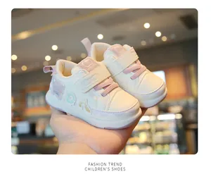 Close-up view of stylish beige baby toddler shoes with pink accents and soft anti-slip soles