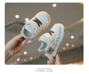 Detail shot of off-white soft sole toddler walking shoes with cute bear patches