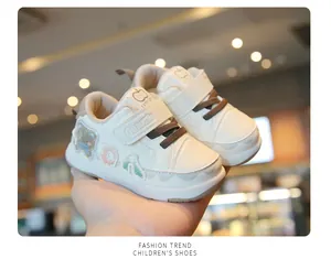 Detail view of white toddler sneakers featuring cute bear patches and adjustable velcro straps.
