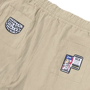 Gros plan de pantalon décontracté en lin avec écussons artistiques sur poches arrière