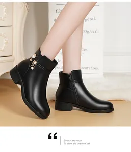 Nahaufnahme eleganter schwarzer Lederstiefeletten für Damen mit Herzanhänger und Blockabsatz
