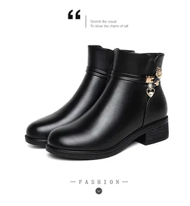 Detailaufnahme schwarzer Stiefeletten aus weichem Leder mit Herzanhänger und Blockabsatz