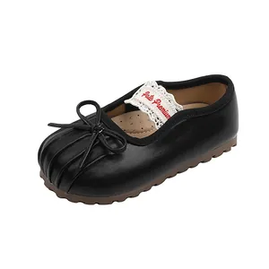 Gros plan de chaussures Mary Jane noires pour fillettes avec nœud et dentelle