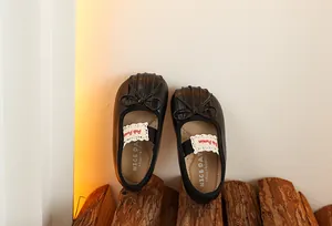 Gros plan de chaussures Mary Jane noires pour bébé fille avec nœud et dentelle