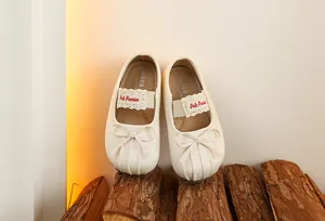 Gros plan sur les ballerines Mary Jane crème pour bébés avec nœud et dentelle