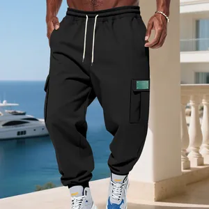 Close-up of men's black cargo sweatpants with drawstring on a sunny sea view terrace