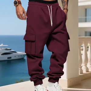 Full detail view of men's burgundy heavy fleece cargo joggers with side pockets on a balcony
