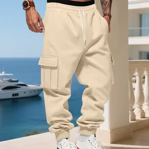 Detail of beige cargo sweatpants with multi-pockets and tapered cuffs in a luxury setting.