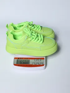 Sneaker chunky verde neon presentate su una bilancia digitale dal peso di 650,3 g.