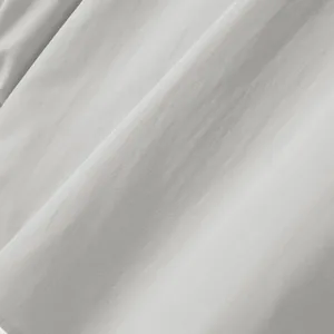 High-resolution close-up of light grey men's shirt fabric showing fine woven texture