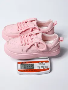 Sneaker rosa con zeppa pesate su una bilancia digitale che indica un peso di 0,659 kg