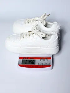Misurazione del peso delle sneakers bianche con zeppa sulla bilancia, 615,6g dettaglio