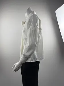 Side profile of a white dropped shoulder men's shirt with a tie detail on a mannequin
