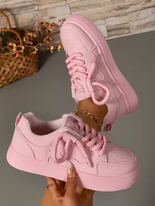 Vista laterale dettagliata di sneakers chunky rosa da donna con spessi lacci intrecciati