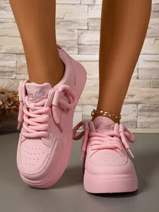 Eleganti sneaker platform rosa con lacci spessi e dettaglio ricamato 'Smile'.