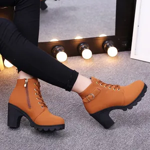 Detailaufnahme brauner Schnürstiefeletten mit hohem Blockabsatz und Schnallendetail