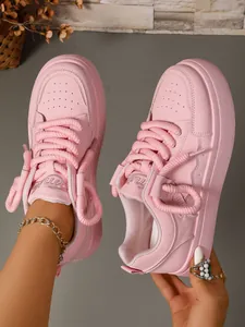 Dettaglio di sneakers rosa con suola platform spessa e lacci in corda dal design alla moda.