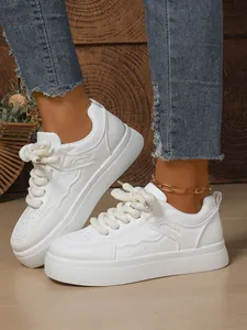 Dettaglio di sneaker bianche con suola spessa e lacci larghi in stile chunky