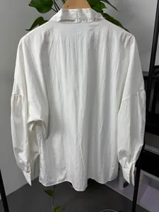 Detailed back view of a white long-sleeved shirt featuring stylish dropped shoulder design