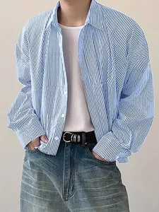 Detailed view of men's casual blue and white vertical striped long sleeve shirt