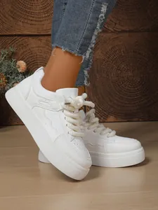 Dettaglio laterale di sneakers bianche con zeppa e lacci spessi da donna alla moda