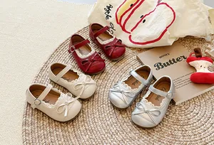 Dettaglio delle scarpe Mary Jane per bambine con bordo in pizzo e fiocco decorativo