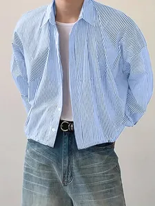 Detail view of stylish men's loose long-sleeve blue striped shirt with classic lapel collar