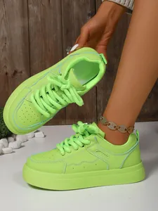 Dettaglio di scarpe pane verde lime con suole platform spesse e lacci spessi decorativi.