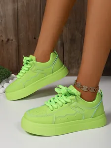 Vista dettagliata di sneaker con plateau verde neon e lacci spessi alla moda
